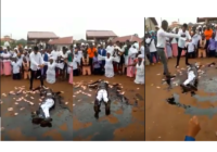 Pastor causes a stir as he rolls in engine oil, while members spray money on him during church crusade (